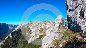 Hohe Weichsel - Couple with a hiking backpacks climbing to the of a big boulder on the way to Hohe Weichsel in Austria