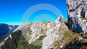 Hohe Weichsel - Couple with a hiking backpacks climbing to the of a big boulder on the way to Hohe Weichsel in Austria