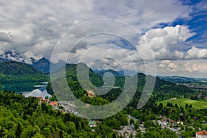 Hohenschwangau castle among green springtime Alpine mountains. Fussen village, Alpsee and Forggensee