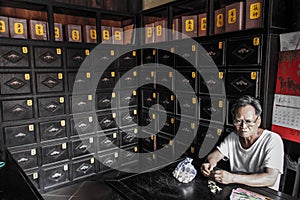 Old man eating peanuts in an old pharmacy, Hoi An, QuÃ¡ÂºÂ£ng Nam Province, Vietnam photo