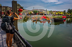 Hoi An Old Quarter decorations on the Thu Bon River, Young woman taking photos from the bridge