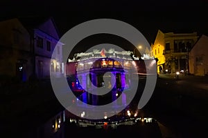 The old Japanese covered bridge colourfully illuminated at night in the heritage town of Hoi An