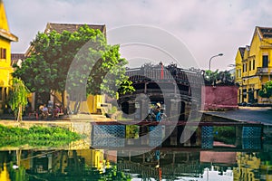 Hoi An, Vietnam - September 02, 2013: The woman is walking with her bicycle over the bridge