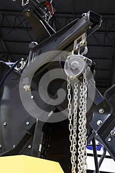 hoist with chain in swing arm of machinery
