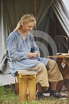 Hojbjerg, Denmark, July 29, 2023: Guy carving wood at viking festival
