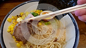 Hokkaido corn butter ramen hot noodle pork slice eating chopsticks top view 4k