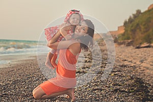 Hokum tender scene of beautiful adorable young mother enjoy life time summer vacation with her little baby girl daughter on sand b