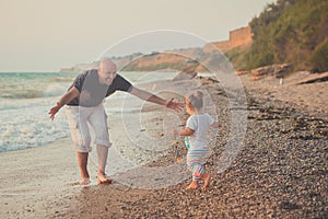 Hokum tender scene of handsome bolt happy father enjoy life time summer vacation with his little baby girl daughter on sand beach.