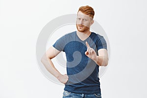 Hold on, I forbid you. Strict serious-looking young dad with ginger hair and beard waving index finger and staring photo