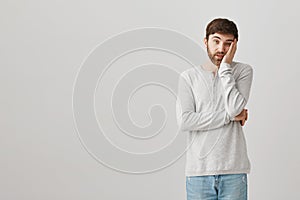 Hold long do I need to listen to this stupid guy. Portrait of bored and amazed male student leaning head on palm while