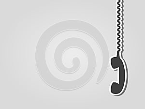 Retro phone receiver hanging on a cable. Gray background with copy space. photo
