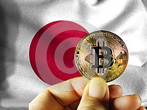 Hold the physical version of Bitcoin (the new virtual currency) and the Japanese flag