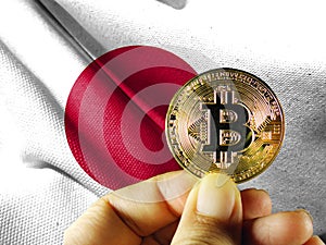 Hold the physical version of Bitcoin (the new virtual currency) and the Japanese flag