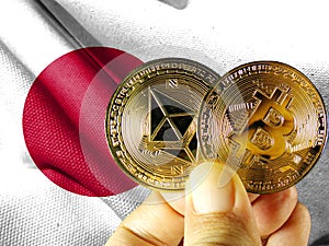 Hold the physical version of Bitcoin (the new virtual currency) and the Japanese flag