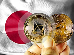 Hold the physical version of Bitcoin (the new virtual currency) and the Japanese flag