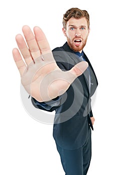 Hold it right there. Studio portrait of a young businessman gesturing to stop with his hand out against a white