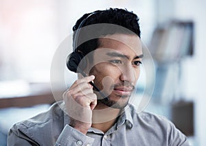 Hold on a second while I find it. a handsome young customer service agent sitting alone in the office and looking