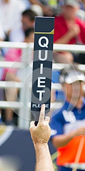 Hold sign Quiet Please in competition golf.