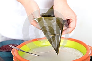 Hold the zong leaves with both hands into a funnel shape and prepare to make zongzi