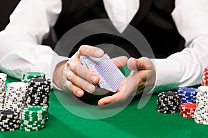 Holdem dealer with playing cards and casino chips