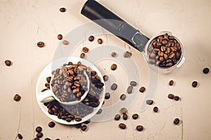 Holder for coffee maker, cup and scattered beans/holder for coffee maker, cup and scattered beans on stone background. Top view