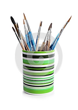 Holder with different paint brushes on white