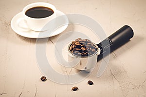 Holder filled with beans and coffee cup/holder filled with beans and coffee cup on a concrete background
