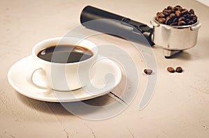 holder filled with beans and coffee cup/ holder filled with beans and coffee cup on a concrete background, selective focus