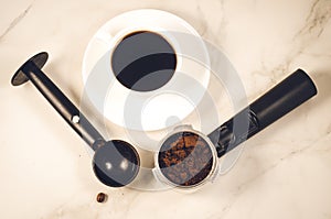 Holder filled with ground coffee, spoon and cup/holder filled wi