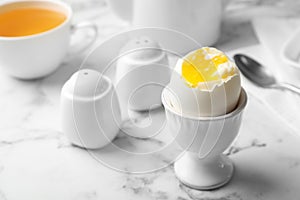 Holder with soft boiled egg on table.