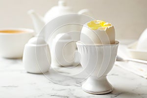 Holder with soft boiled egg on table