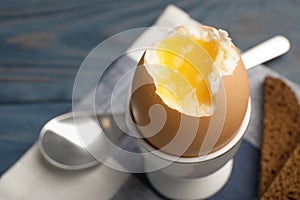 Holder with soft boiled egg on table, closeup