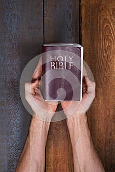 Holding the Bible over table