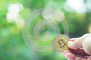 Bitcoin in hand with green blur background, bitcoin concept, copy space