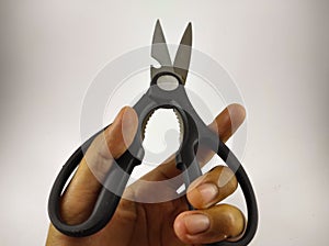 Holding black scissor on white