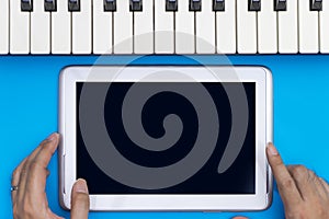 Holding Blank tablet screen mock up music keyboard for Music concept