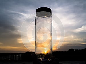 Holding bottle at sunset