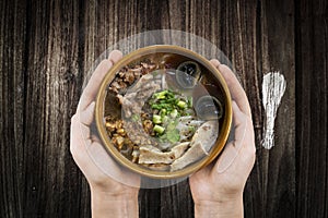 holding bowl Homemade noodle Vietnam food, Traditional Vietnamese soup and rice pudding on a wooden background, pork noodle rice