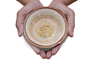Holding a bowl of white sesame seeds on white background