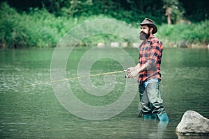 Holding brown trout. Fly angler man on the river. Bearded retro fisherman and trophy trout. Catch fish.