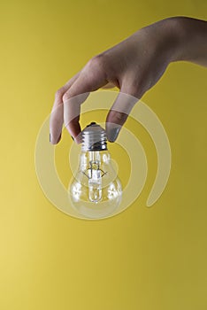 Holding Bulb idea on yellow background