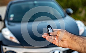 Holding a car remote with lock and unlock buttons. selective focus with blurred background