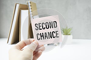 holding a card with text SECOND CHANCE