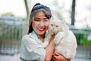 Woman holding cat playing at home with love for cats The smile glints in his bond with his fluffy pet cat. The relationship of photo