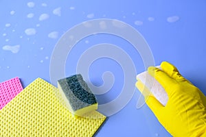 Holding a cleaning sponge on a blue background