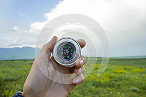 Holding a compass on the background of the field