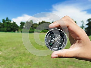 Holding a compass, blurry sea background Using wallpaper or travel background or navigator image