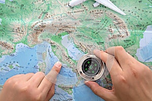 Holding a compass in hand to look up a certain location on the map of Europe