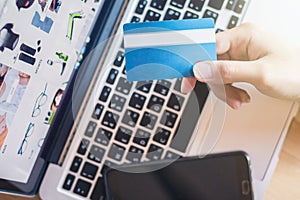 Holding credit card in front of laptop