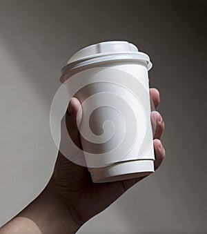 Holding a cup of coffee for taking away photo
